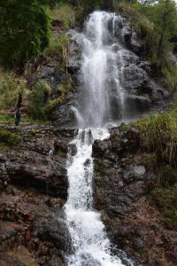 una persona parada frente a una cascada en HOTEL HUANTA - MORENOS en Huanta