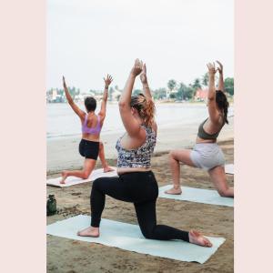 a group of women doing yoga on the beach at Cycling Backpacker Hostel in Unawatuna