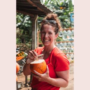 a woman is holding a pumpkin and smiling at Cycling Backpacker Hostel in Unawatuna