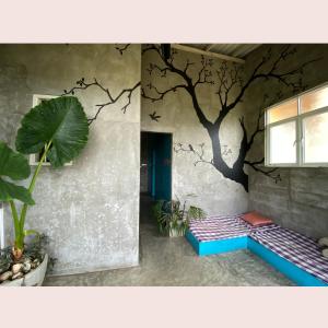 een kamer met een boom op de muur bij Cycling Backpacker Hostel in Unawatuna