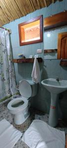 a bathroom with a toilet and a sink at El Pajas in Puerto Velasco Ibarra