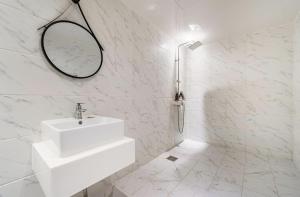 bagno bianco con lavandino e specchio di gray195hotel a Gimhae