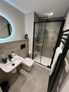 a bathroom with a shower and a toilet and a sink at Cozy Intimate Apartment - Leeds in Leeds