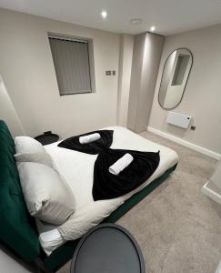 una camera da letto con un letto con lenzuola nere e uno specchio di Cozy Intimate Apartment - Leeds a Leeds