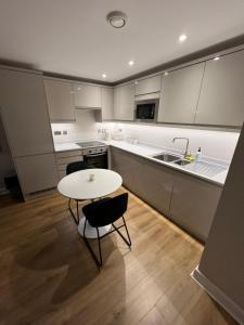 una cucina con tavolo, sedie e lavandino di Cozy Intimate Apartment - Leeds a Leeds