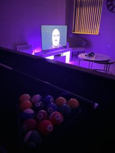 a dark room with a tv and a bunch of balls at Spacious Modern Apartment - Leeds City Centre in Leeds