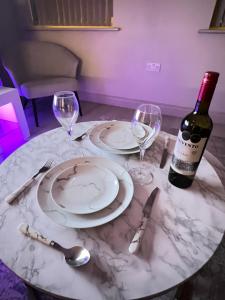 una mesa con dos platos y una botella de vino en Spacious Modern Apartment - Leeds City Centre en Leeds