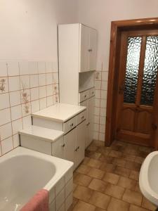 La salle de bains est pourvue d'une baignoire, de toilettes et d'un lavabo. dans l'établissement Hostel Odlot Ławica pokoje na wyłączność, à Poznań