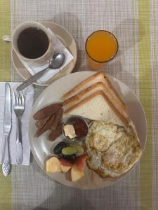 a plate with an egg and toast and a cup of coffee at Wild Horizons Guest House in Sauraha