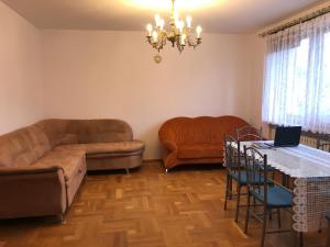 sala de estar con sofá y mesa con ordenador portátil en Hostel Odlot Ławica pokoje na wyłączność en Poznan