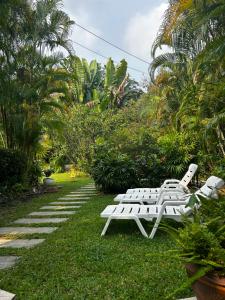 two white lounge chairs sitting on the grass at The Terrace, spacious 3 bedroom luxury pool villa in Ko Chang