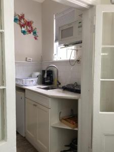 eine Küche mit einer Spüle und einer Mikrowelle in der Unterkunft Downtown Nassau Oasis Unit 1 in Nassau