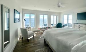 a bedroom with a bed and a chair and windows at The View suites and breakfast in Triton, Newfoundland in Pilleyʼs Island