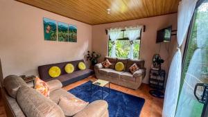 een woonkamer met 2 banken en een tafel bij Casa Euphonia Monteverde in Monteverde Costa Rica