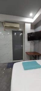 a room with a bed with a door and a television at HYTON GRAND in Urapakkam