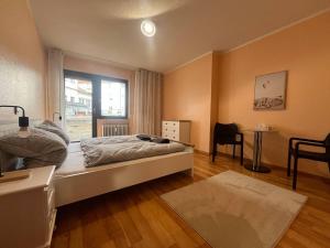 1 dormitorio con cama, mesa y ventana en Simplex Apartments An Der Dreisam, en Freiburg im Breisgau