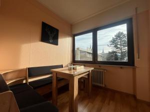 ein Wohnzimmer mit einem Tisch und einem großen Fenster in der Unterkunft Simplex Apartments An Der Dreisam in Freiburg im Breisgau