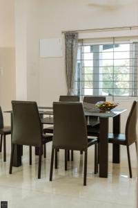a dining room with a table and chairs at Reunion Solandis - Service Apartments in Udupi