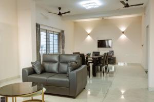 a living room with a couch and a table at Reunion Solandis - Service Apartments in Udupi