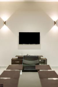 a living room with a flat screen tv on the wall at Reunion Solandis - Service Apartments in Udupi