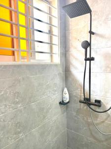 a shower in a bathroom next to a window at Ayan Villas in Accra