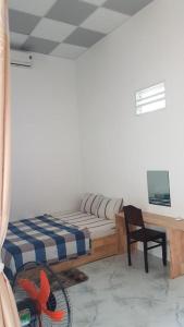 Schlafzimmer mit einem Bett, einem Schreibtisch und einem Stuhl in der Unterkunft Hoa Lan Motel & Homestay in Giồng Tú Ðiền
