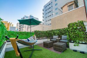 a patio with a hammock and a chair and an umbrella at 夏5GWifi TokyoDome皇居1km〜 RoofGarden 上野秋葉原銀座東京2km～都心 in Tokyo