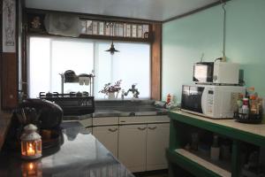 una cucina con lavandino e forno a microonde di omusubi guest house (JAPANESE　STYLE） a Mamihara