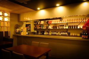 a bar with a table and a shelf with bottles at Sapporo Oriental Hotel in Sapporo