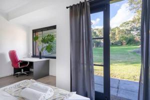 a bedroom with a bed and a desk and a window at Cozy Villa Near Chadstone Fashion Capital in Chadstone