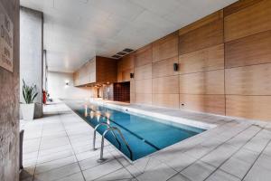 a large swimming pool in a room with wooden walls at The Spencer Suite - Cityscape Panorama with Pool in Melbourne