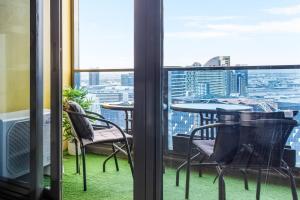 a room with tables and chairs and a view of a city at The Spencer Suite - Cityscape Panorama with Pool in Melbourne