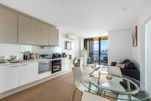 a kitchen and a dining room with a glass table at The Spencer Suite - Cityscape Panorama with Pool in Melbourne
