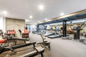 a gym with several treadmills and cardio machines at The Spencer Suite - Cityscape Panorama with Pool in Melbourne