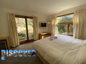 a bedroom with a bed and a large window at Ramshead Creek 3 in Thredbo