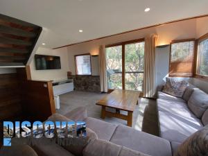 a living room with a couch and a table at Ramshead Creek 3 in Thredbo