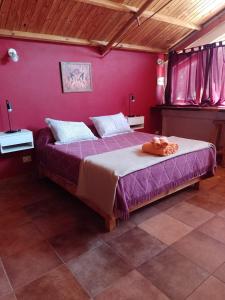 1 dormitorio con 1 cama grande y pared de color rosa en Depa centro comercial en Villa Pehuenia