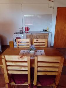 uma cozinha com uma mesa de madeira com 2 cadeiras e uma mesa; em Depa centro comercial em Villa Pehuenia