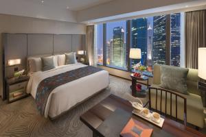 um quarto com uma cama grande e uma janela grande em Mandarin Oriental Pudong, Shanghai em Xangai