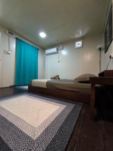a bedroom with two beds and a blue curtain at Seahorse Diver Guesthouse in Perhentian Island