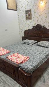 a wooden bed in a room with a table at Authentic Indian Culture in Panchkula