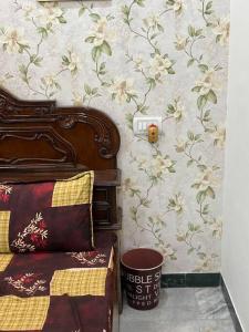 1 dormitorio con 1 cama y una pared con flores en Authentic Indian Culture en Panchkula