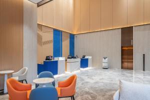 un vestíbulo con mesas y sillas azules y naranjas en Holiday Inn Express Changsha Yuhua, an IHG Hotel, en Changsha