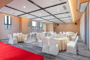 a room with tables and chairs and a flat screen tv at Holiday Inn Express Changsha Yuhua, an IHG Hotel in Changsha