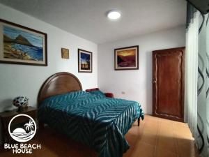 プエルト・チカマにあるBlue Beach House Chicama - Departamentosのベッドルーム(ベッド付)1室、青いビーチハウス1室