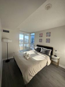 - une chambre dotée d'un grand lit avec un ours en peluche dans l'établissement Beautiful and Central 3 Bedroom Condo with Parking, à Toronto