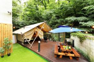 首爾的住宿－CS Avenue Tourist Hotel，天井设有帐篷、桌子和长凳
