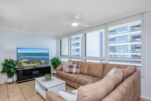 a living room with a couch and a tv at Oceanview Delight in Gold Coast