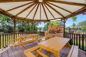 a wooden gazebo with a picnic table and a grill at Oceanview Delight in Gold Coast