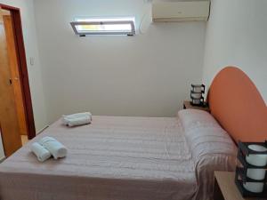 uma cama num quarto com duas toalhas em Alquiler temporario. El Paraná em Paraná